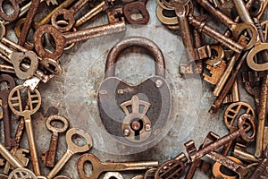 Vintage rusty padlock surrounded by old keys