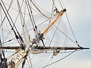 Vintage sailing ship mast ropes and tackle, Tall ship rigging mast detail, blue sky