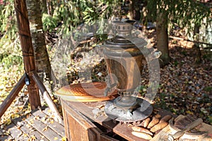 Vintage samovar, standing on the bedside table and waiting to be melted with fir cones, open air. against the background