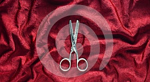 Vintage scissors on a red fabric background. Top view