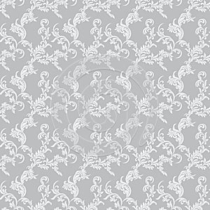 Vintage seamless pattern. White luxurious Vegetative tracery of stems and leaves isolated on a gray background.
