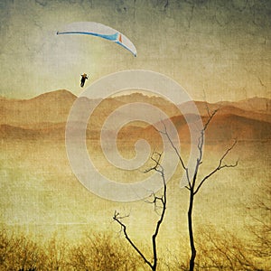 Vintage sepia landscape with paragliding in flight