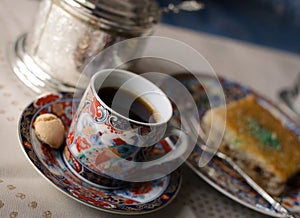 Vintage set of beautiful painted cup of coffee, honey cake Baklava and sugar bowl. Selective focus