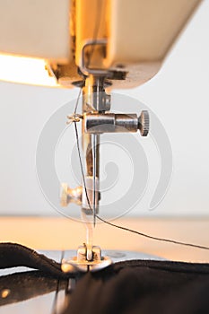 Vintage sewing machine closeup detail needle black thread fabric