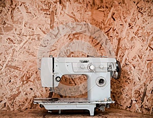 Vintage Sewing machine on flakeboard background