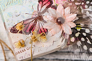 Vintage shabby chic background with dried flowers, paper flower, feathers and butterfly