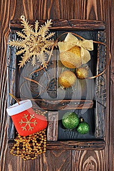 Vintage shadow box with golden and green christmas ball on wood background