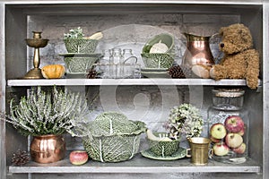 Vintage shelf with antiques, dishes and toys. Heather, candlestick, teddy bear