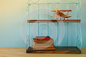 Vintage shelf with old wooden plane toy and books