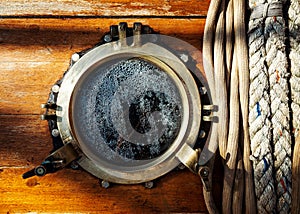 Vintage ship brass porthole and ropes