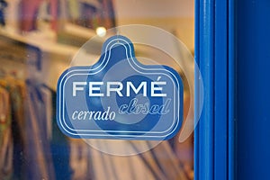 Vintage shop sign ferme in french and cerrado in spanish text means english shop closed photo
