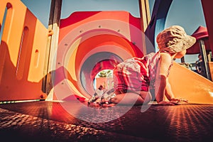 Vintage shot of baby profile crawling inside orange playground structure children point of view