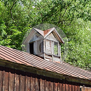 Vintage shuttered barn cupola sits on rustic tin roof