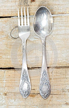 Vintage silver fork and spoon on wooden background