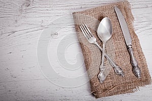 Vintage silver tableware knife, spoon and fork is on napkin