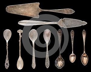 Vintage Silverware, antique spoons, knives, cake shovels isolated on isolated black background. Antique silverware. Retro