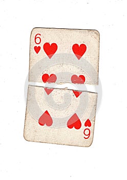 A vintage six of hearts playing card torn in half.