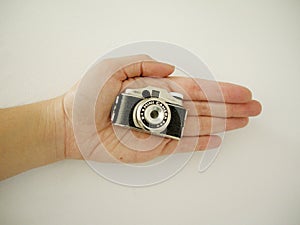 Vintage small camera in the hands of a woman photo