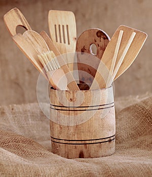 Vintage small wooden bucket with various kitchen utensils