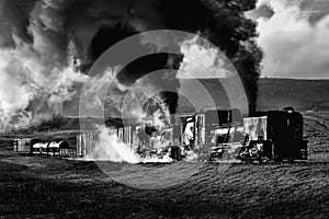 A vintage South African narrow-gauge steam locomotives steaming uphill on a cold winters morning.