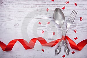 Vintage spoon and fork with a red tape, angels and butterflies for Valentine`s day on a wooden