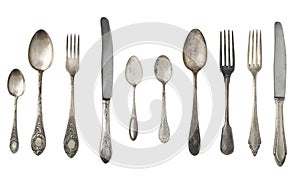 Vintage spoons, forks and knives isolated on a white background.