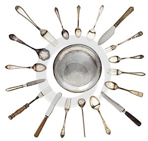 Vintage spoons, knives, forks and a plate lined isolated on white background