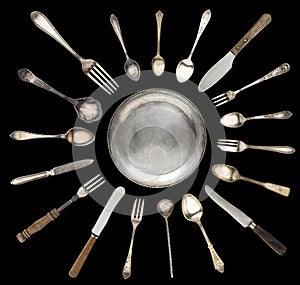 Vintage spoons, knives, forks and a plate lined with sun isolated on a white background.