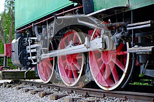 Vintage steam locomotive detail with cranks and red wheels