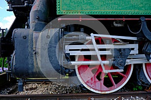 Vintage steam locomotive detail with cranks and red wheels