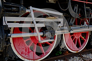 Vintage steam locomotive detail with cranks and red wheels