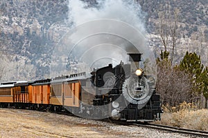 Vintage Steam Train Billowing Smoke as it Moves Through the Mountains