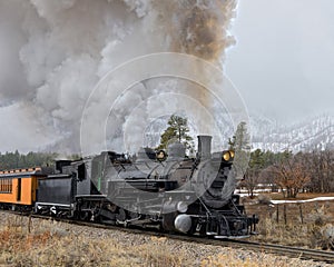 Vintage Steam Train Billowing Smoke and Steam as it Moves Through the Mountains