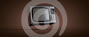 vintage steel and metal television levitating on a brown background, noise in the screen