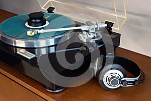 Vintage Stereo Turntable Record Player With Blue Colored Disk, Headphones and Black Weight Clamp