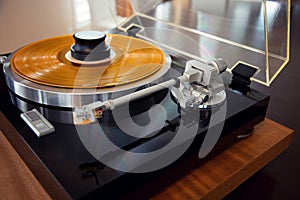 Vintage Stereo Turntable Record Player Tonearm Above Yellow Colored Vinyl