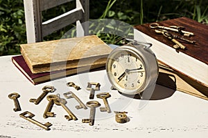 Vintage still life with old alarm clock, keys and books