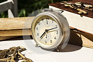 Vintage still life with old alarm clock, keys and books