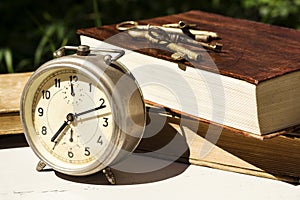 Vintage still life with old alarm clock, keys and books