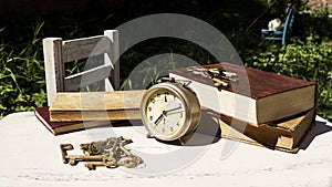 Vintage still life with old alarm clock, keys and books