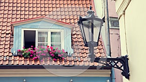 Vintage street lamp on wall and window in garret roof