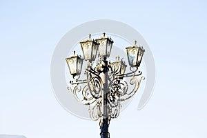 Vintage street light.black street lamp in an open blue sky . Street lantern on background blue sky . Old street light.