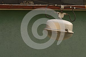 Vintage Street Light Lamp hanging next to a green wall with copy space