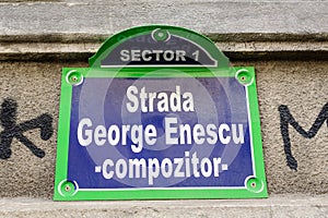 Vintage street sign showing Strada George Enescu (George Enescu Street) displayed on an street