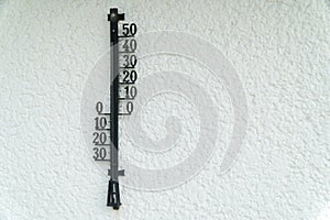 vintage street thermometer on the white wall. Sommer