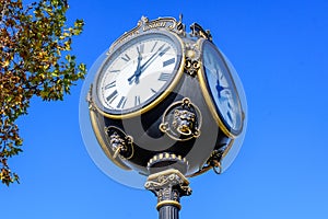 Vintage style black and grey metallic clock towards clear blue sky in Unirii Park Parcul Unirii, in Bucharest, Romania, in a