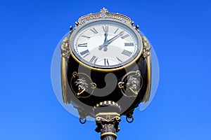 Vintage style black and grey metallic clock towards clear blue sky in Unirii Park Parcul Unirii, in Bucharest, Romania, in a