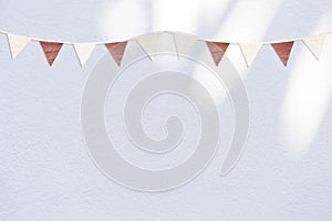 Vintage style bunting flag on white cement wall background