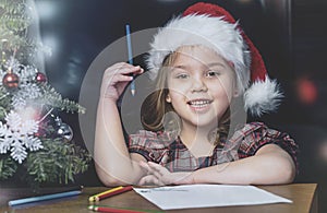 Vintage style child Christmas portrait. Girl write letter to Santa. New year holidays