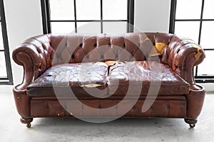 Vintage style . Defective old leather sofa on white room